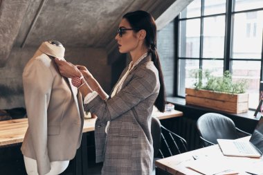 Ceket yaka onun atölyesinde dururken manken üzerinde ayarlama Eyewear ciddi genç kadın