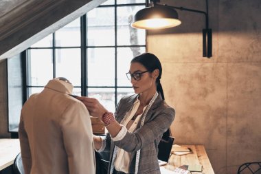 Ceket yaka onun atölyesinde dururken manken üzerinde ayarlama Eyewear ciddi genç kadın