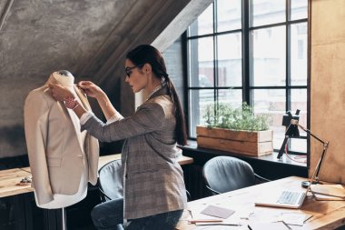 Ceket yaka onun atölyesinde dururken manken üzerinde ayarlama Eyewear ciddi genç kadın