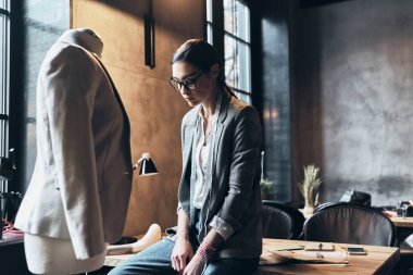 Masanın üstünde onun atölyesinde vakit süre eğilerek Eyewear yorgun genç kadın