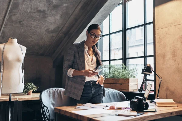 Attraktive Junge Frau Brille Mit Smartphone Schreibtisch Ihrer Werkstatt — Stockfoto