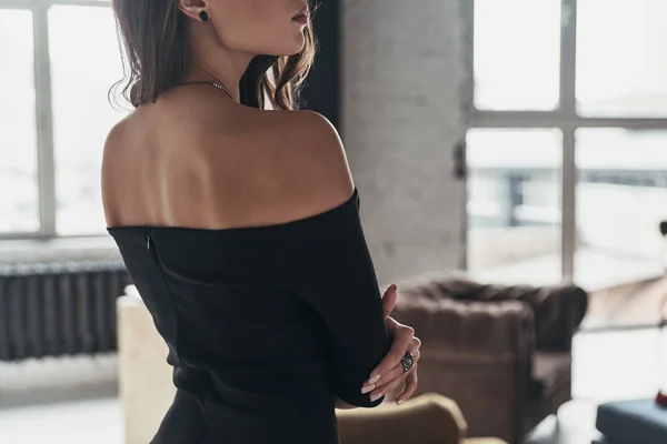 美丽的女人在优雅的黑色礼服摆在家里的部分看法 — 图库照片