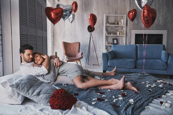 美丽的年轻夫妇拥抱 而躺在床上 在家里与心脏气球 — 图库照片