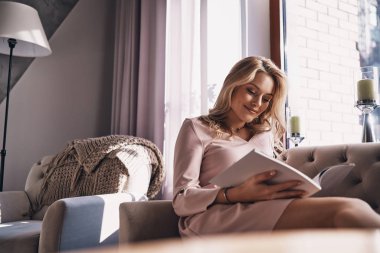 kanepe ve okuma dergi oturan güzel sarışın kadın