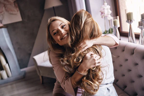 Happy Young Women Embracing Smiling While Sitting Sofa — Stock Photo, Image