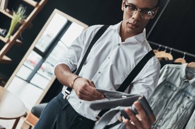 Bir kravat dururken showroom holding ciddi genç adam