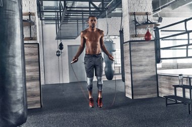 gömleksiz erkeklik Afrika adam spor salonunda egzersiz yaparken ile ip atlama