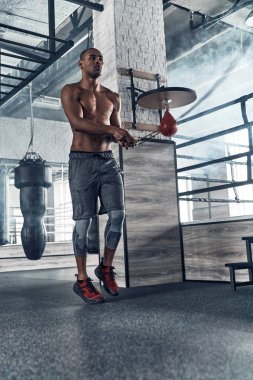 gömleksiz erkeklik Afrika adam spor salonunda egzersiz yaparken ile ip atlama