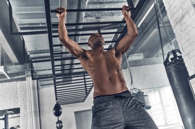 Spor salonunda egzersiz yaparken pull-up yapan gömleksiz kas Afrika erkek
