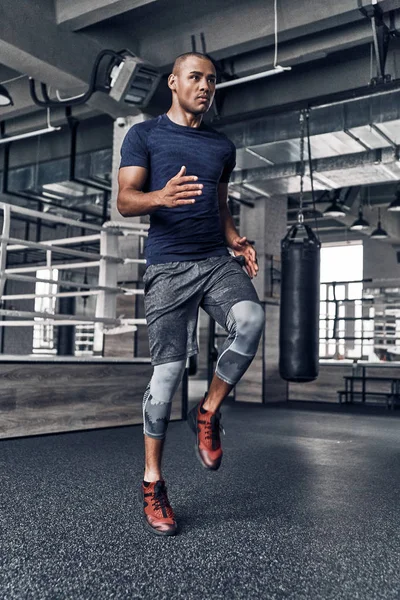 Joven Africano Musculoso Ropa Deportiva Saltando Mientras Hace Ejercicio Gimnasio —  Fotos de Stock