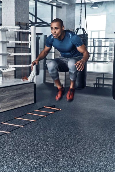 Jovem Homem Africano Musculoso Roupas Esportivas Pulando Enquanto Exercita Ginásio — Fotografia de Stock