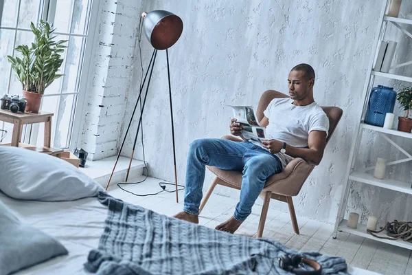 Yakışıklı Genç Afrika Adam Evde Koltukta Otururken Gazete Okuma — Stok fotoğraf