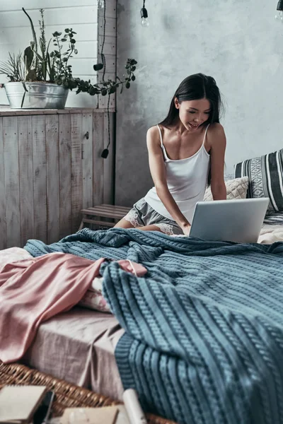 Freelancer Vrouw Met Behulp Van Computer Glimlachen Terwijl Zittend Bed — Stockfoto