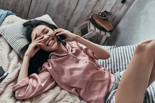 Laughing Asian Young Woman Talking Smart Phone While Lying Bed — Stock Photo, Image
