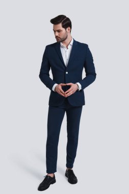 Tam takım sıktı ve uzak duran gri arka planı arıyorum elinde tutmak emin adam