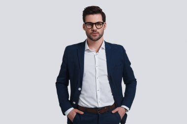 Elleri ceplerinde tutmak ve stüdyoda poz genç işadamı