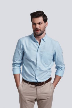 Elleri ceplerinde tutmak ve stüdyoda poz karışık genç işadamı