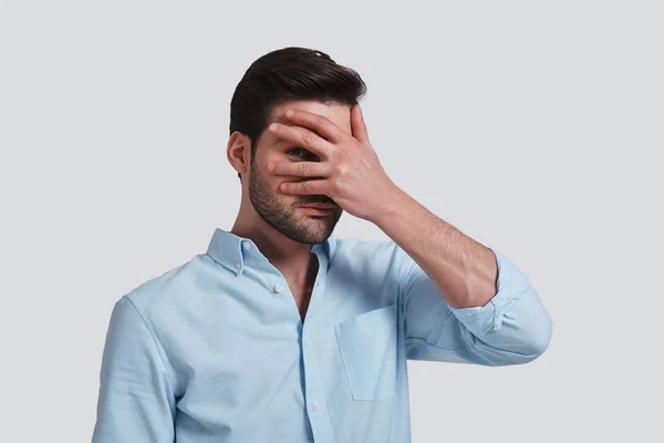 Handsome Caucasian Man Covering Eyes Hand Peeking While Standing Grey — Stock Photo, Image