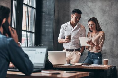 Dijital tablet kullanma ve office fikirleri tartışmak genç meslektaşları smart casual giyim 