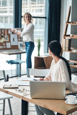 Atölye çalışmasında, moda tasarımcıları gösteri salonunda çalışan iki genç kadınlar