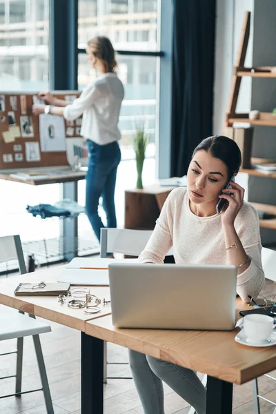 Brünette Frau Telefoniert Während Ihr Kollege Der Tafel Plant — Stockfoto