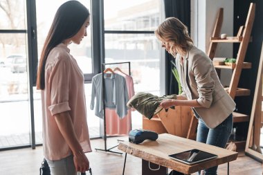 satış temsilcisi kadın moda butik çalışırken müşteri için gömlek katlama