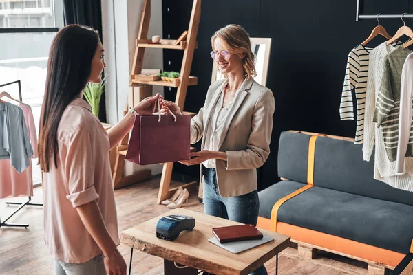 Blond Kvinna Ger Shopping Väska Till Kunden Medan Arbetar Modebutik — Stockfoto