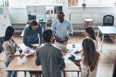 Grup ofis toplantı sırasında tartışan genç iş adamları 