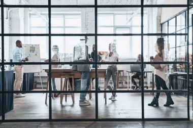 Grup genç iş adamları ofiste tartışıyor 