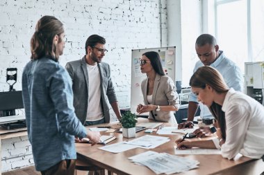 Resepsiyon kağıt belgeleri ile ofiste stratejisinde tartışırken iş takım