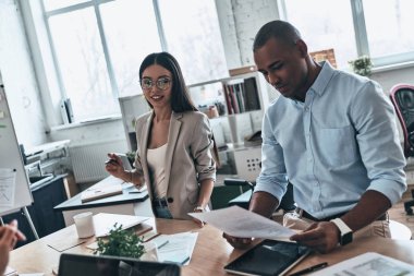Ofis Masası oturma ve kağıt belgeleriyle çalışma iş adamları 