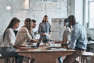 Grup ofis toplantı sırasında tartışan genç iş adamları 