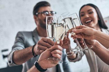 İş arkadaşları ve arkadaşlar. Grup birbirlerine toasting ve yönetim kurulu odasında dururken gülümseyen genç iş adamları