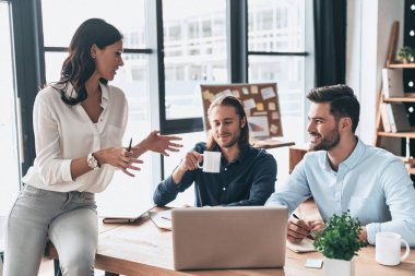 Kendinden emin ve başarılı takım. Birlikte çalışan ve ofiste vakit ise gülümseyen genç modern iş arkadaşları smart casual giyim