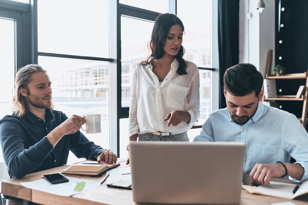 Just working day. Young modern colleagues in smart casual wear working together while spending time in the creative office