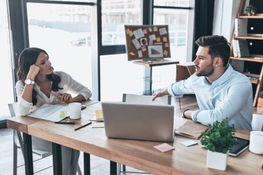 Fikir paylaşımı. Ofiste otururken konuşurken iki modern gençlerin smart casual giyim