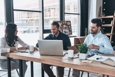 Genç profesyoneller. Yaratıcı ofiste otururken iş tartışırken akıllı rahat kıyafet içinde modern gençlerin grup 