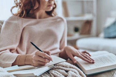 Güzel genç kadın evde yatakta yatan süre kitap okuma ve fikirler yazma 