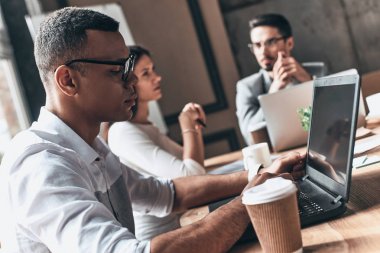 Genç modern insanların yaratıcı ofis dizüstü bilgisayarlar ile çalışan 