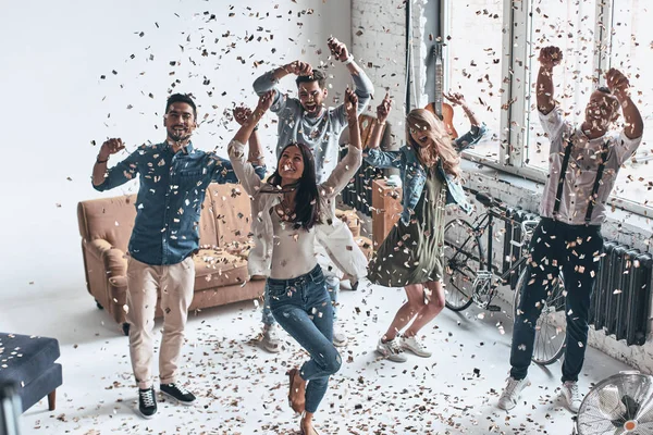 Jovens Felizes Fazendo Festa Casa Com Confetes Voando Todos Lugares — Fotografia de Stock