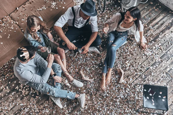 Top View Modern Young People Louring Champagne While Sitting Floor — стоковое фото