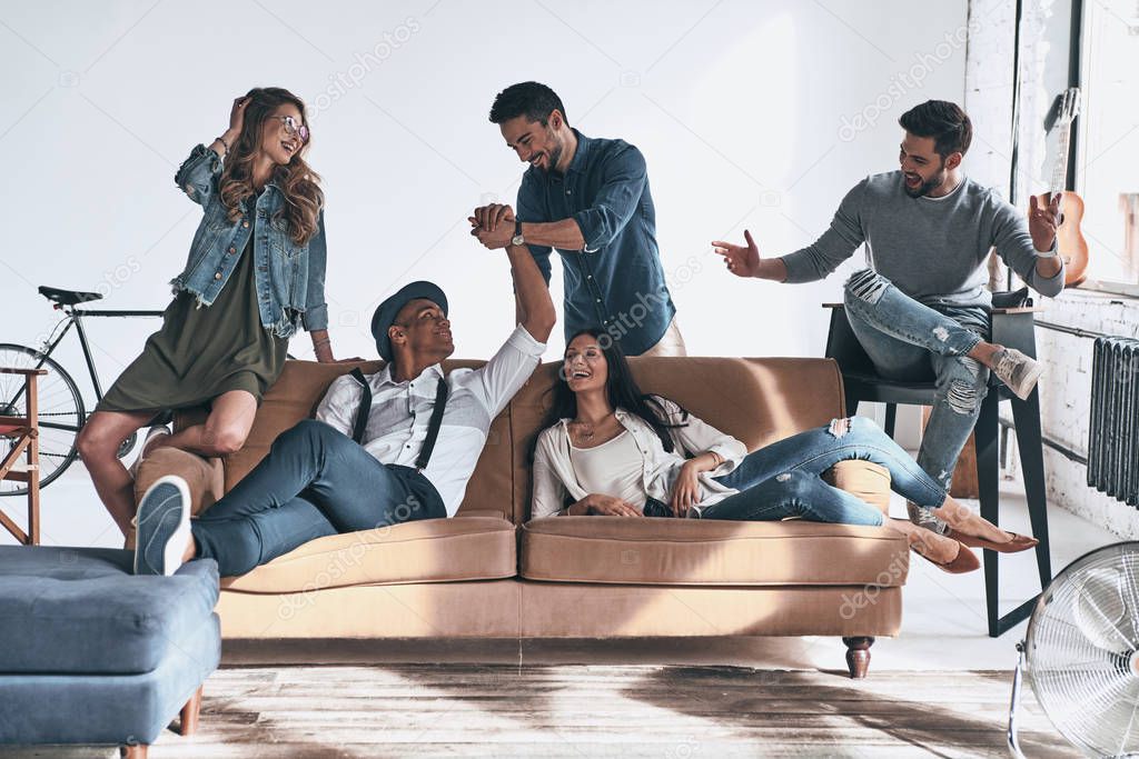 group of happy young people in casual relaxing on sofa