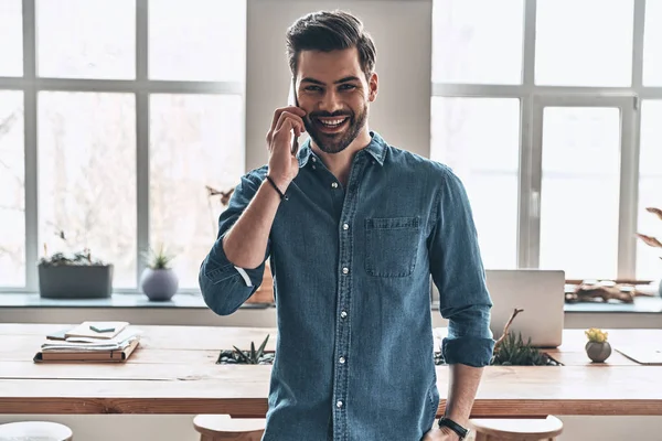 Glücklicher Schöner Junger Mann Der Büro Mit Einem Smartphone Spricht — Stockfoto