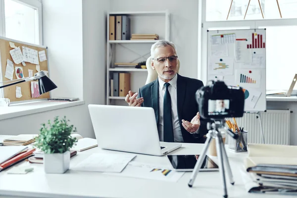 Senior muž v elegantní košili a kravatu pracuje pomocí notebooku při vytváření videa sociálních médií — Stock fotografie