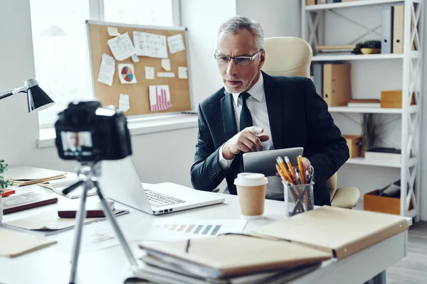 Hombre mayor en traje de negocios elegante usando tableta digital mientras hace video de redes sociales — Foto de Stock