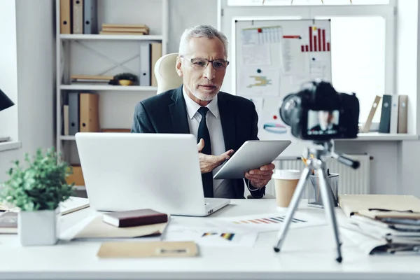 Senior man in elegant business suit using digital tablet while making social media video — Stock Photo, Image