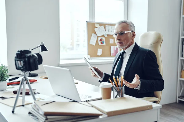 Hombre mayor en traje de negocios elegante usando tecnologías modernas mientras hace video en redes sociales — Foto de Stock