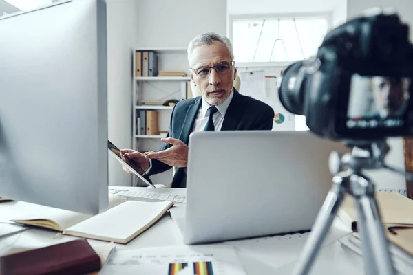 Senior man in elegant business suit using modern technologies while making social media video — Stock Photo, Image