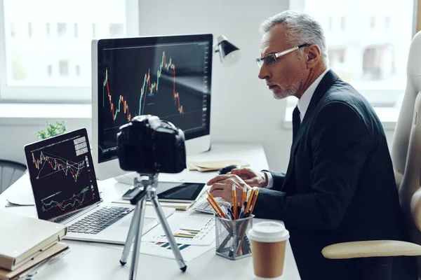 Hombre mayor en traje de negocios elegante usando tecnologías modernas mientras hace video en redes sociales — Foto de Stock