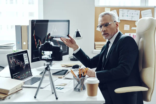 Hombre mayor en traje de negocios elegante usando tecnologías modernas mientras hace video en redes sociales — Foto de Stock